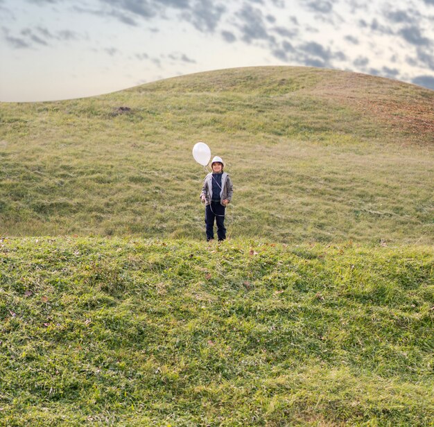 Petit enfant avec des ballons sur Prairie