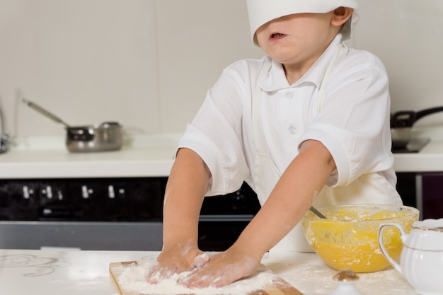 Petit enfant cuisant dans une toque de chefs