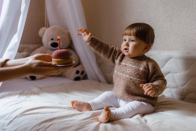 Petit enfant dégustant un gâteau avec une bougie petit enfant et un gâteau avec une bougie