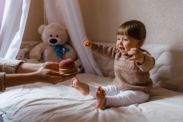 Petit enfant dégustant un gâteau avec une bougie petit enfant et un gâteau avec une bougie