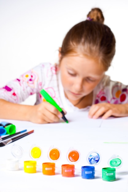 Petit enfant dessinant sur un fond blanc