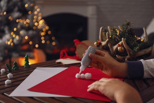 Petit enfant faisant la carte de Noël au plan rapproché de table en bois