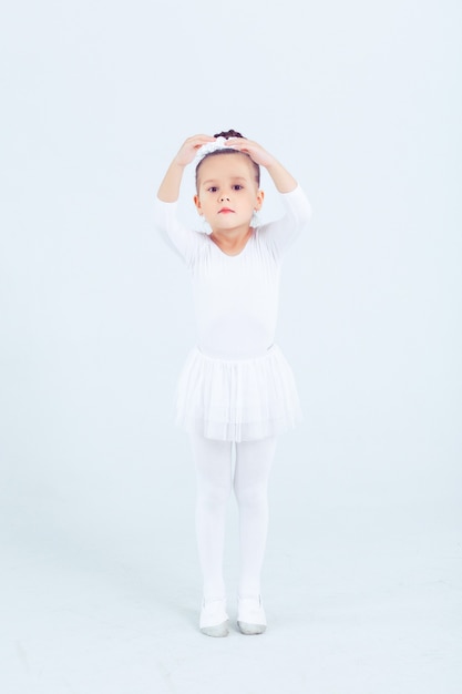 Petit enfant fille ballet de danse à fond blanc Portrait de petite ballerine souriant