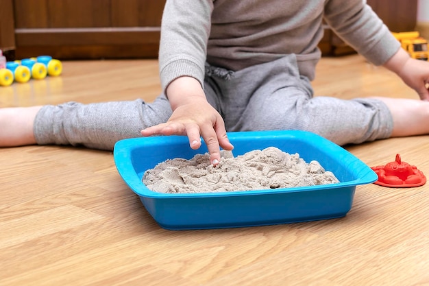 Petit enfant garçon jouant à la maison dans une boîte sensorielle avec du sable cinétiqueDéveloppement de la motricité fineÉducation sensorielle précoce Activités Créativité Montessoriart à la garderiematernelle