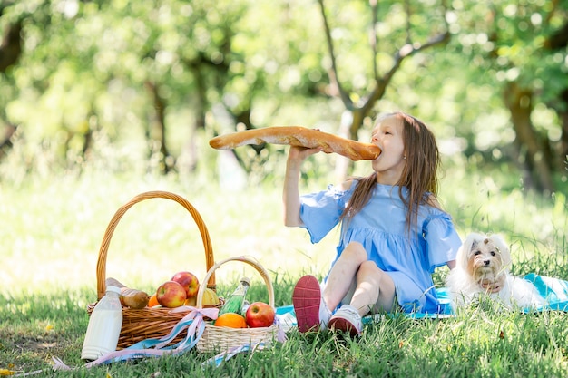 Petit enfant avec gros pain sur pique-nique dans le parc