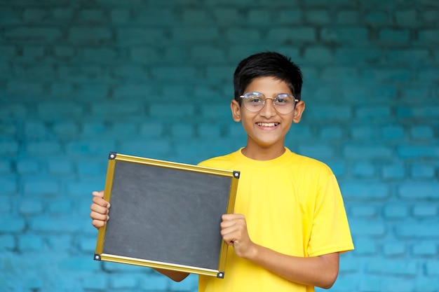 Petit enfant indien montrant le tableau avec espace de copie