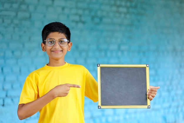 Petit enfant indien montrant le tableau avec espace de copie