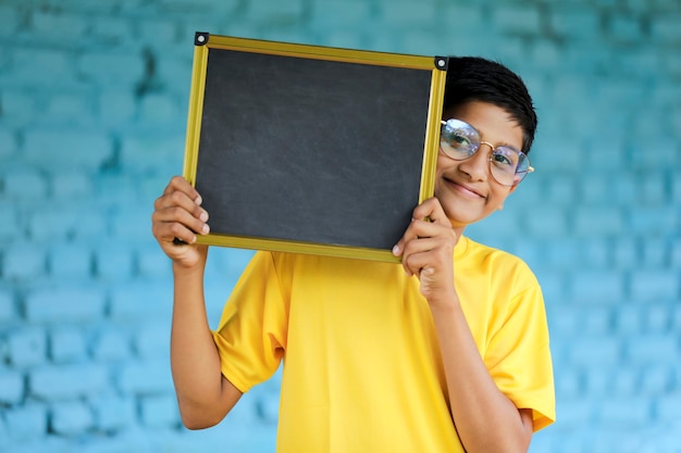 Petit enfant indien montrant le tableau avec espace de copie