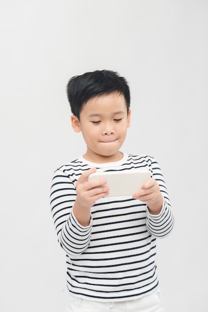 Petit enfant jouant à des jeux sur smartphone