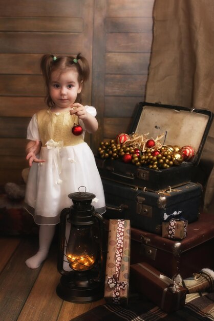 Petit enfant jouant avec des jouets dans une pièce avec des décorations de Noël