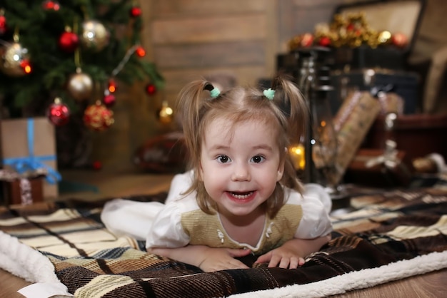 Petit enfant jouant avec des jouets dans une pièce avec des décorations de Noël