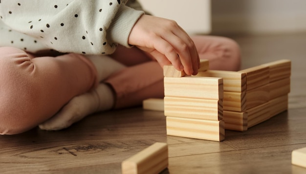 Un petit enfant joue à un jeu de société construit à partir de blocs de briques en bois Jeux éducatifs pour enfants