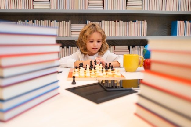 Petit enfant jouer aux échecs Enfant garçon jouant au jeu de société Pensée brainstorming enfant et idée dans le jeu d'échecs École d'échecs et concept d'éducation des enfants
