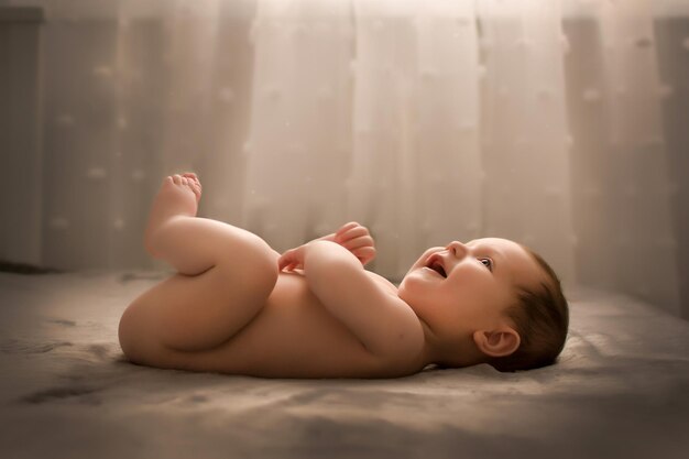 Petit enfant sur le lit devant la fenêtre