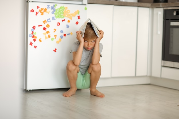 Petit enfant avec un livre sur la tête