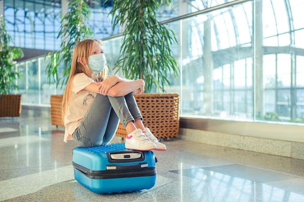 Petit enfant en masque médical à l'aéroport en attente d'embarquement