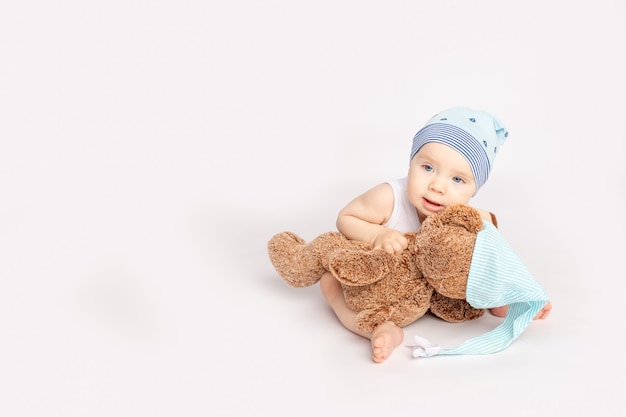 Petit enfant avec un ours en peluche sur fond blanc isolé