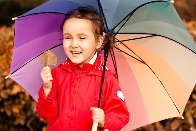 Petit Enfant Avec Parapluie Arc-en-ciel Multicolore à L'extérieur