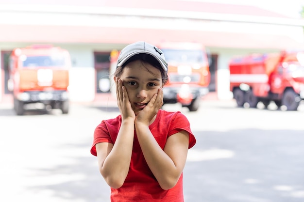 petit enfant près d'un camion de pompiers rouge.