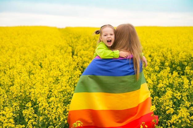 Un petit enfant sincère embrasse sa mère avec un drapeau LGBT