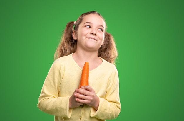 Petit enfant souriant avec carotte fraîche