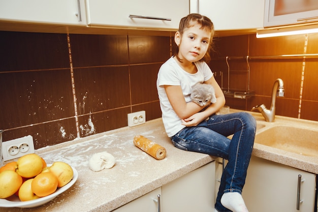 petit enfant en t-shirt blanc jouant à la maison avec minou