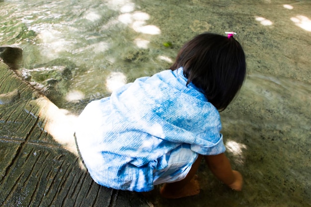 Photo petit enfant thaïlandais enfants mignons garçon et parent famille voyageur visite et jeu de natation à la cascade namtok sai yok noi ou aux cascades nam tok khao phang dans la ville de saiyok à kanchanaburi en thaïlande