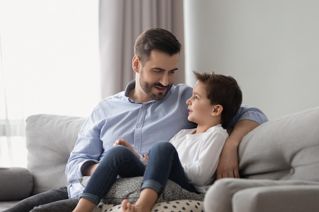 Le petit fils a une conversation de confiance avec son père à la maison.