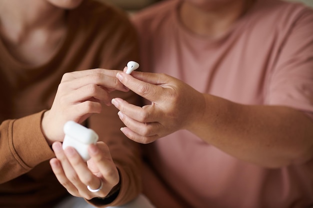 Petit-fils donnant des écouteurs à grand-mère