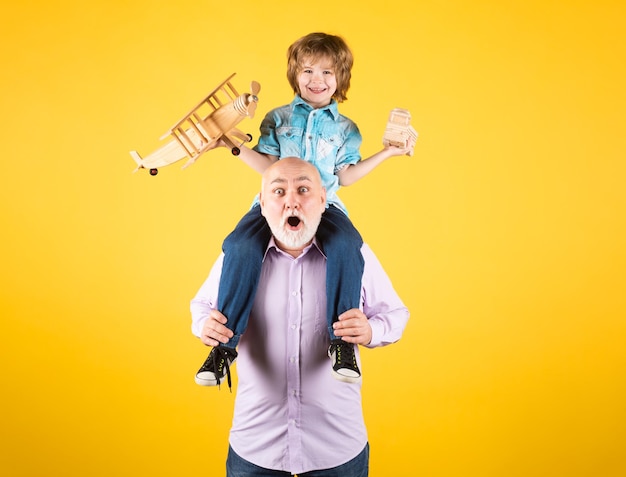 Petit-fils enfant et grand-père ferroutage avec avion et camion jouet en bois hommes génération grand-père