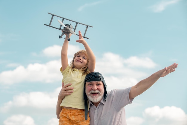 Petit-fils enfant et grand-père jouant avec un avion jouet sur fond de ciel d'été âges de générations