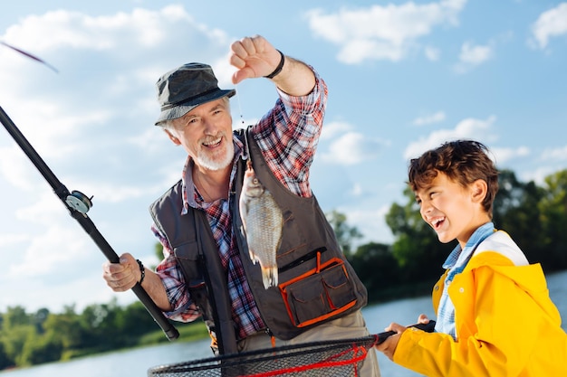 Le petit-fils et le grand-père se sentent vraiment heureux après avoir attrapé du poisson