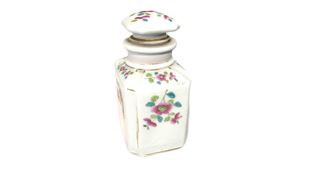 Un petit flacon de parfum avec un motif floral sur le dessus.