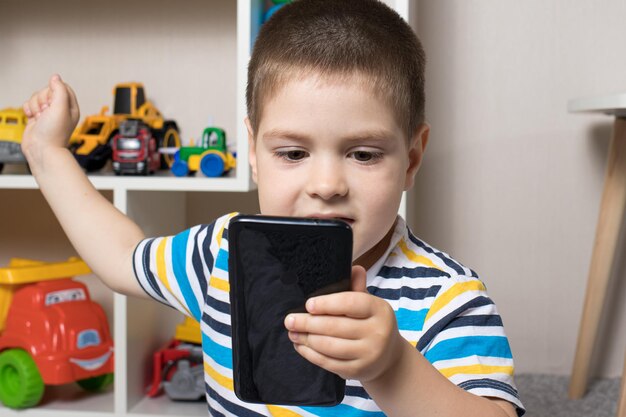 Un petit garçon de 3 à 4 ans regarde l'écran de la tablette.