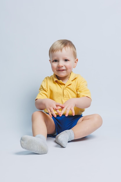 Petit garçon de 3 ans dans un t-shirt jaune et un short bleu un garçon en uniforme de sport