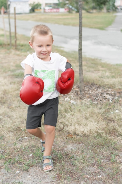 Un petit garçon de 45 ans portant des gants de boxe rouges dans la rue