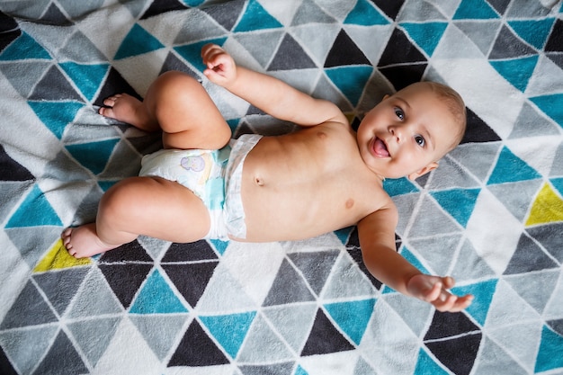 Petit garçon de 8 mois et souriant. Il porte une couche. Santé et développement des enfants