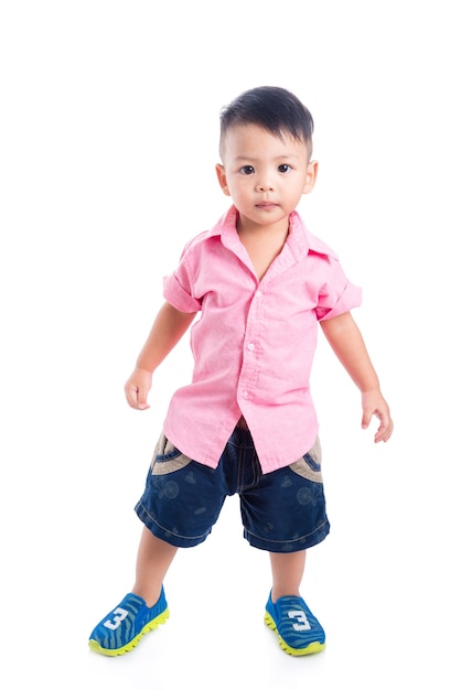 Petit garçon d&#39;âge préscolaire asiatique portant chemise rose debout sur fond blanc