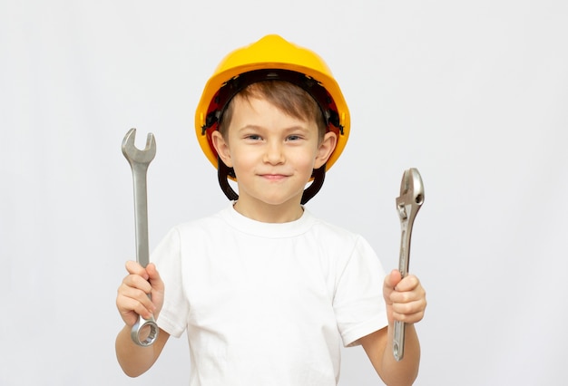 Petit garçon à l'aide d'outils à la maison petit constructeur dans le casque et a vu le travail de réflexion sur l'avenir