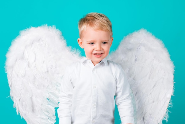 Petit garçon avec des ailes habillé comme un ange, isolé.