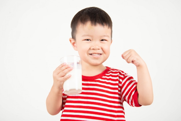 Petit garçon asiatique, boire du lait de verre avec visage heureux