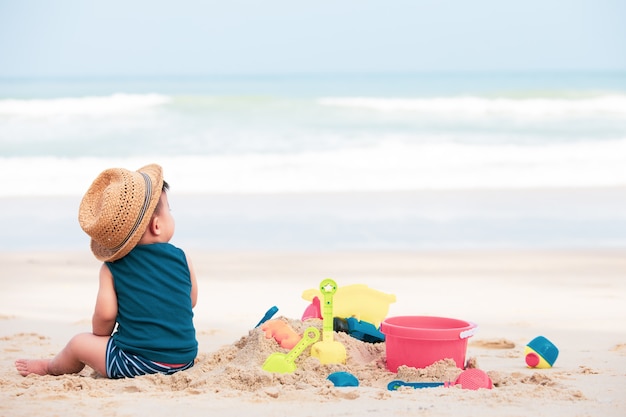 Petit garçon asiatique jouant du sable sur la plage, bébé âgé d&#39;un an