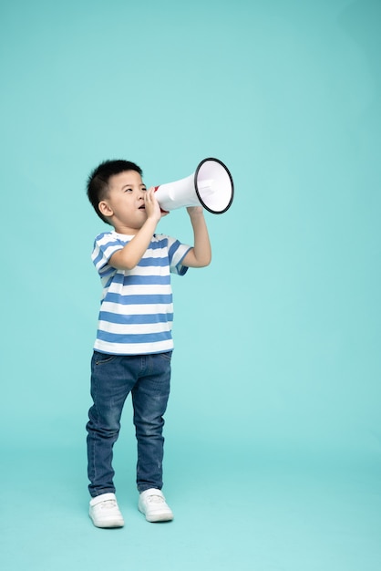 Petit garçon asiatique tenant un mégaphone isolé sur fond vert Discours et annonce le concept