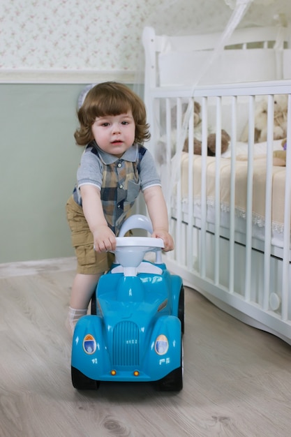 Petit garçon assis sur une petite voiture