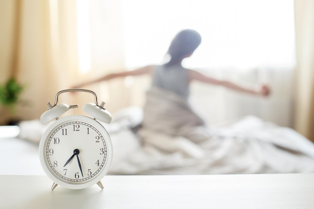 Petit garçon assis et s'étirant dans le lit à la maison le matin