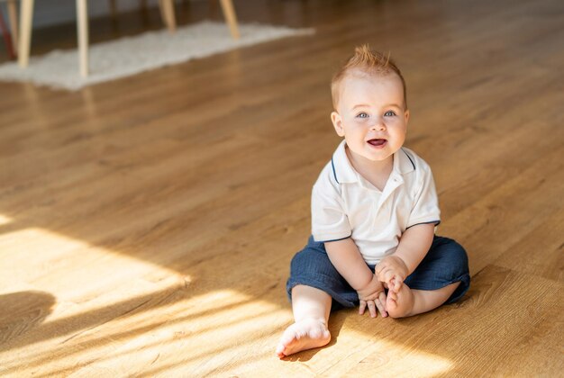 Un petit garçon assis sur le sol avec les jambes croisées