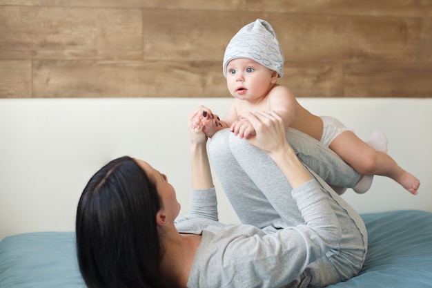 Petit garçon au bonnet rigolo faisant des exercices avec sa mère