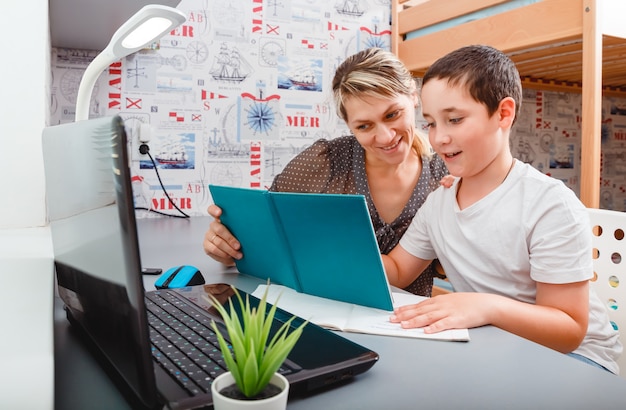 Petit garçon ayant des cours avec tuteur à la maison. Tuteur d'école élémentaire. École à domicile pour élève.