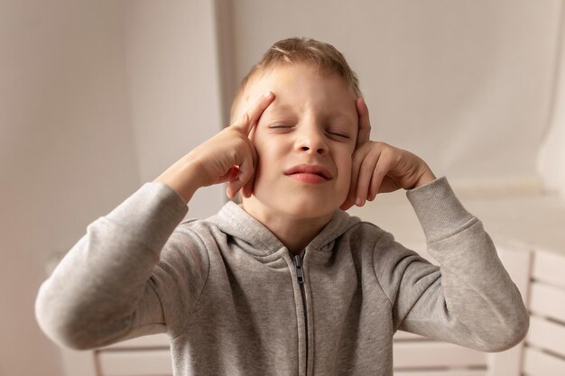 Petit garçon ayant mal à la tête Tragédie du désespoir Maux de tête Enfant souffrant de migraine