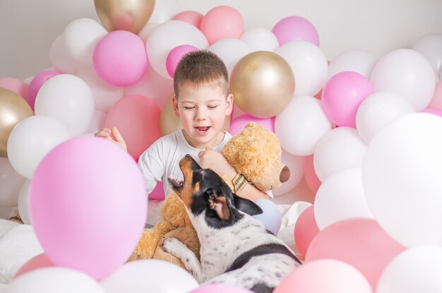 Petit garçon en ballons blancs avec lui chien